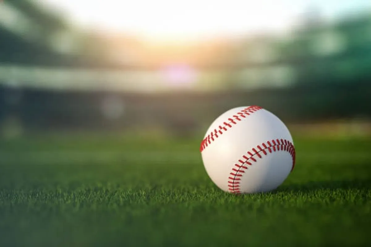 A bright, lively exterior shot highlighting a grassy field with a baseball and hints of a ballgame in progress. The mood is energetic, hinting at opportunities for both playing and spectating local sports events.