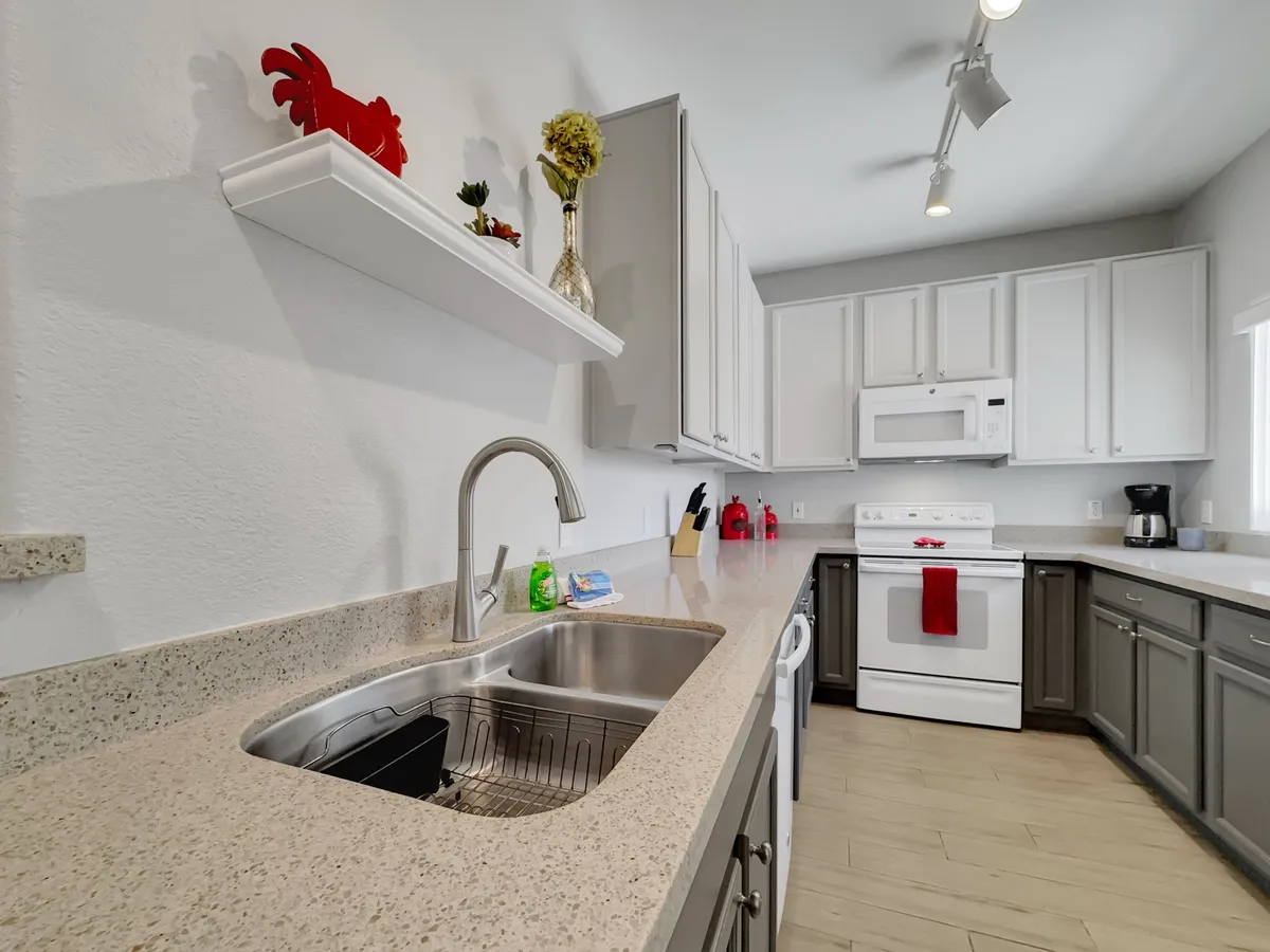 A close-up view of a kitchen area highlighting the kitchen sink, countertop, contemporary appliances, and decorative items. The arrangement suggests warmth and functionality, ideal for both cooking and social gatherings.